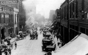 Black and white photo of old Morris Ave with Model T's and Horse Draw Carriages