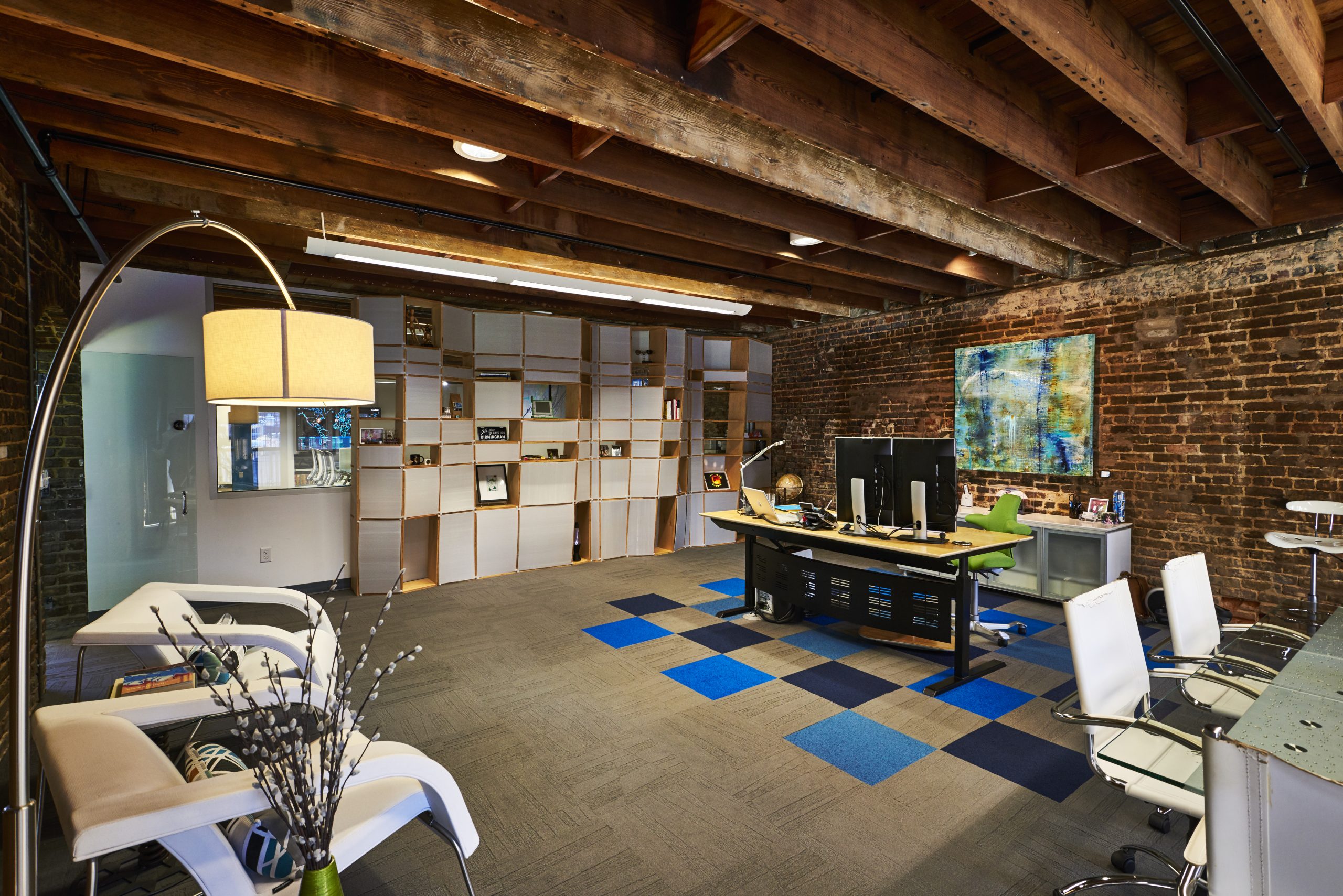 Photo of office defined by Kinetic's signature shelves and a portion of the floor featuring a carpeted section of alternating tiles of Kinetic's colors.