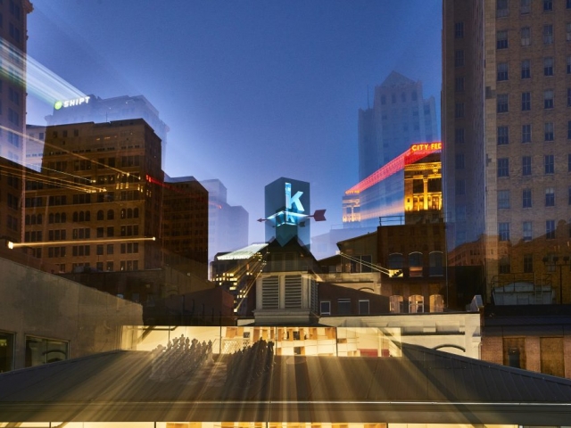 Photo of Kinetic's rooftop logo among buildings in Birmingham with motion blur.