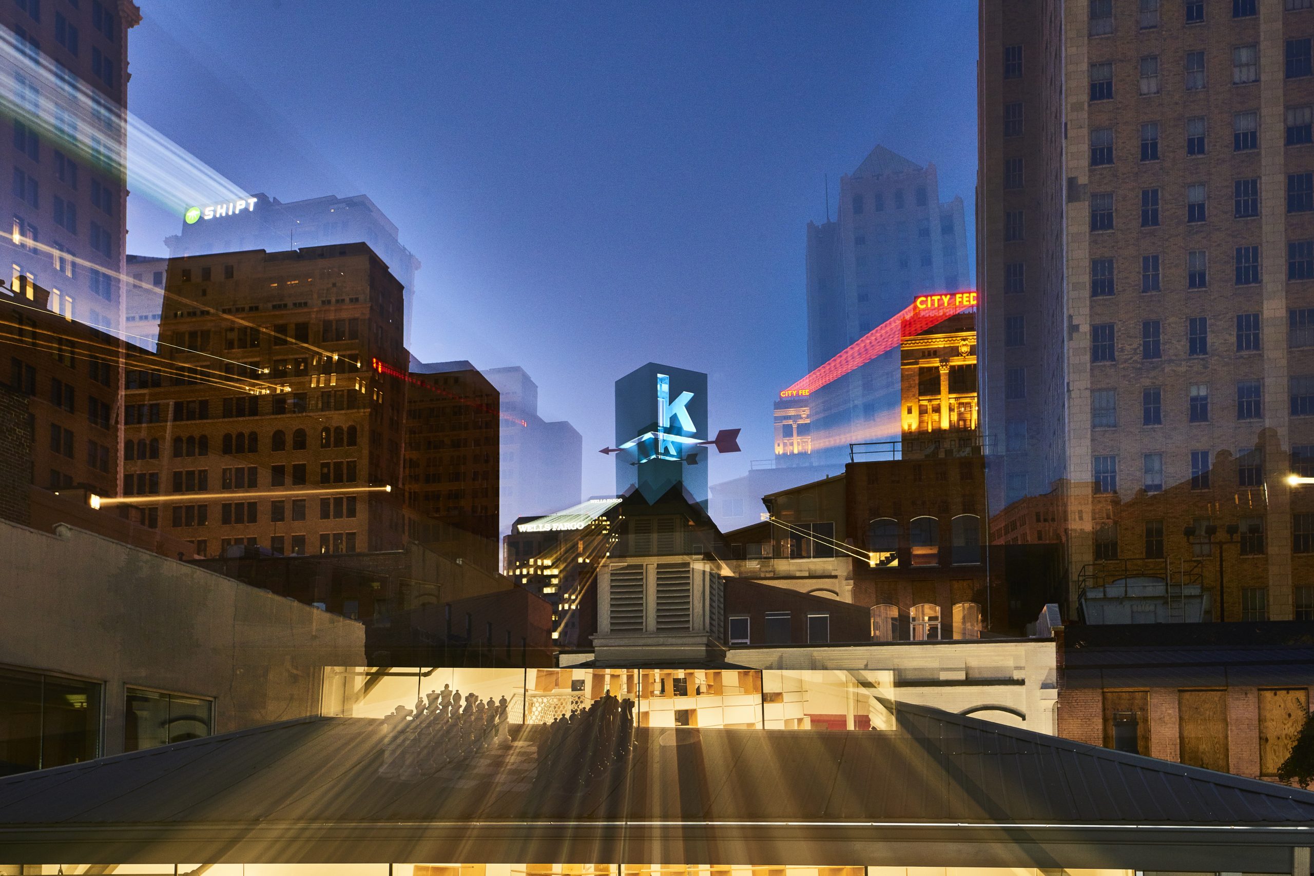 Photo of Kinetic's rooftop logo among buildings in Birmingham with motion blur.